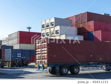 コンテナヤードとトレーラーで運ばれるコンテナ 90831233