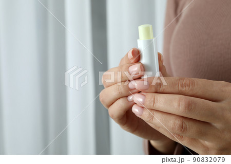Woman holds hygienic lipstick, space for text 90832079
