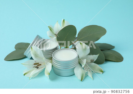Eco lip balm and flowers on blue background Eco lip balm and flowers on blue background 90832756