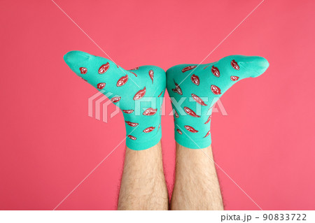 Male legs in socks with meat slices on pink background Male legs in socks with meat slices on pink background 90833722