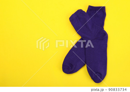 Pair of violet socks on yellow background Pair of violet socks on yellow background 90833734