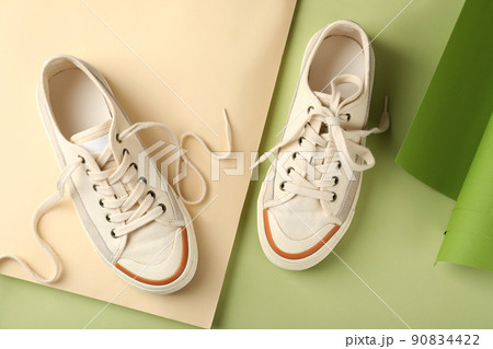 Pair of beige sneakers on two tone background Pair of beige sneakers on two tone background 90834422