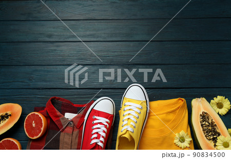 Summer clothes concept with sneakers on wooden background 90834500