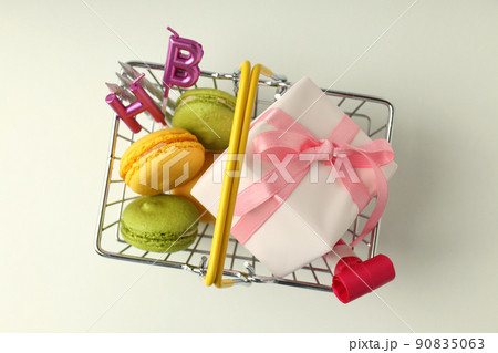 Shop basket with birthday accessories on white background Shop basket with birthday accessories on white background 90835063