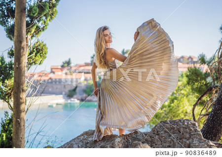 Woman tourist on background of beautiful view of the island of St. Stephen, Sveti Stefan on the Budva Riviera, Budva, Montenegro. Travel to Montenegro concept 90836489