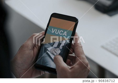 man with a smartphone that reads the text VUCA man with a smartphone that reads the text VUCA 90836712