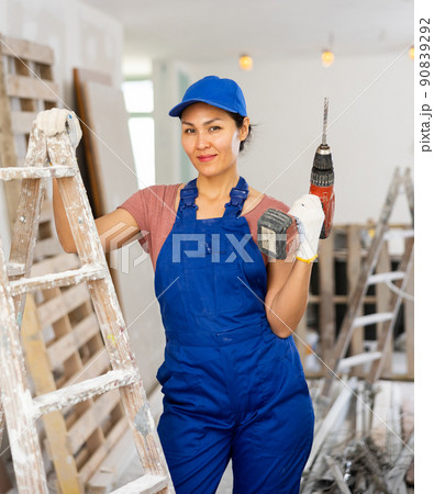 Portrait of smiling asian woman repairer with drill Portrait of smiling asian woman repairer with drill 90839292