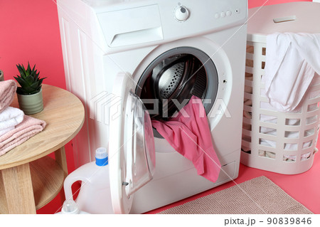 Concept of housework with washing machine on pink background Concept of housework with washing machine on pink background 90839846