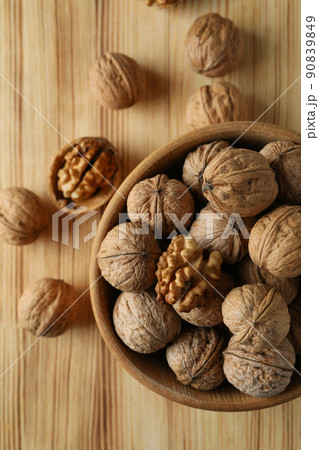 Walnuts in wooden bowl on wooden background Walnuts in wooden bowl on wooden background 90839849