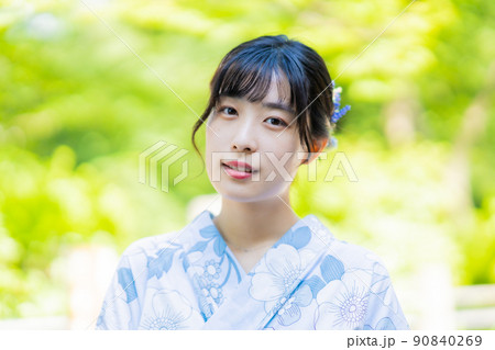 浴衣で日本庭園でポーズをとる若い女性 90840269