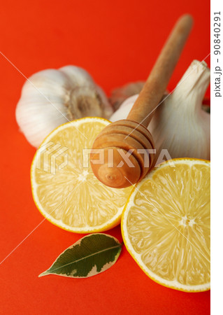 Concept of treatment colds with honey and garlic on orange background 90840291