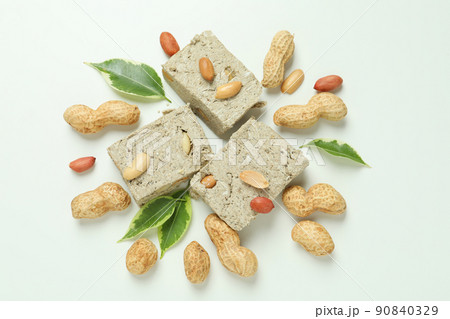 Concept of tasty food with halva and nuts on white background 90840329