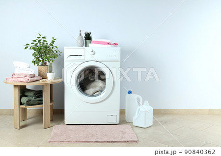 Concept of housework with washing machine against white wall Concept of housework with washing machine against white wall 90840362
