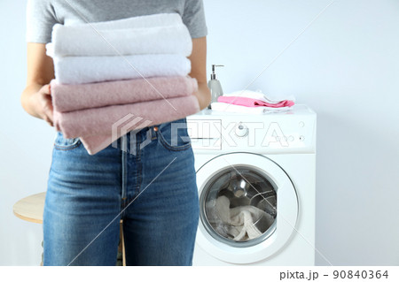 Concept of housework with washing machine and girl on white background Concept of housework with washing machine and girl on white background 90840364