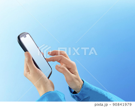スマホをタップする手_青空背景 90841979