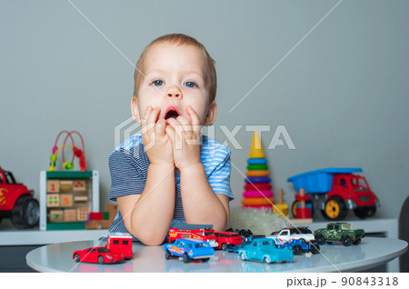 Toddler boy plays in playroom with educational toys... 90843318