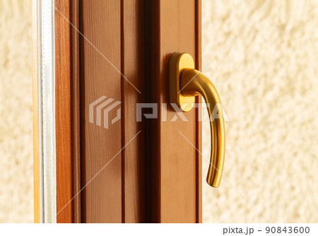 Golden metal window or door handle close-up Golden metal window or door handle close-up 90843600
