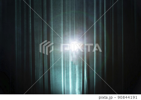 Background of a dark green theater curtain with a beam from a light source. Stage background. Background of a dark green theater curtain with a beam from a light source. Stage background. 90844191