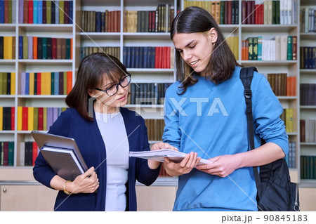 Talking female teacher and guy college student, in the library room 90845183