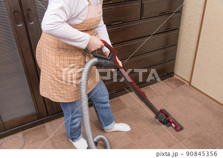 【サイクロンクリーナーで絨毯を掃除するミドル主婦】 90845356