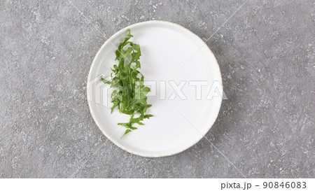 Arugula lettuce leaves on a white plate 90846083