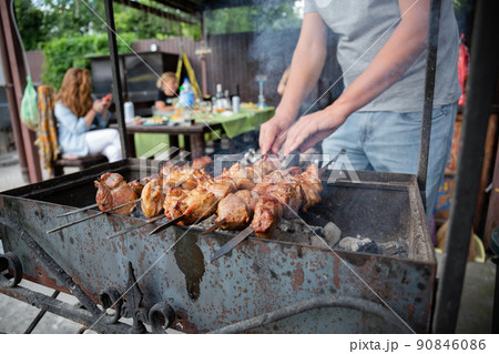 BBQ picnic with kebabs and meat on an open fire on a summer day in the backyard of a private house. 90846086