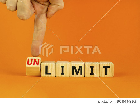 Limit or unlimit symbol. Businessman turns wooden cubes and changes the concept word Limit to Unlimit. Beautiful orange table orange background. Business limit or unlimit concept. Copy space. 90846893