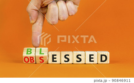 Blessed or obsessed symbol. Businessman turns wooden cubes and changes the concept word Obsessed to Blessed. Beautiful orange table orange background. Business blessed or obsessed concept. Copy space. 90846911