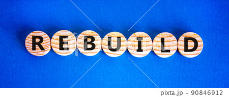Rebuild and build symbol. The concept word Rebuild on wooden circles. Beautiful blue background, copy space. Business rebuild and build concept. Rebuild and build symbol. The concept word Rebuild on wooden circles. Beautiful blue background, copy space. Business rebuild and build concept. 90846912