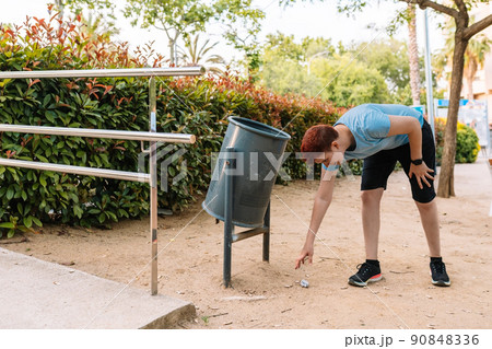 young urban girl, picking up rubbish from the ground to deposit it in a litter bin. young woman environmentalist in city. young urban girl, picking up rubbish from the ground to deposit it in a litter bin. young woman environmentalist in city. 90848336