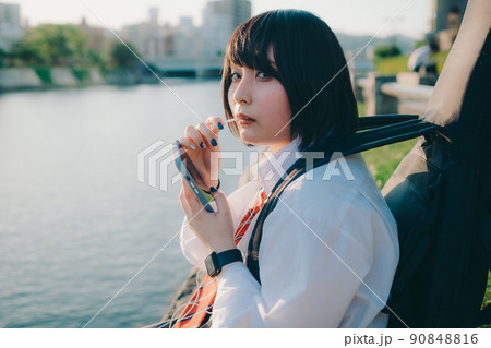 ギターとスマートフォン持った制服姿の女子高生と街 ギターとスマートフォン持った制服姿の女子高生と街 90848816