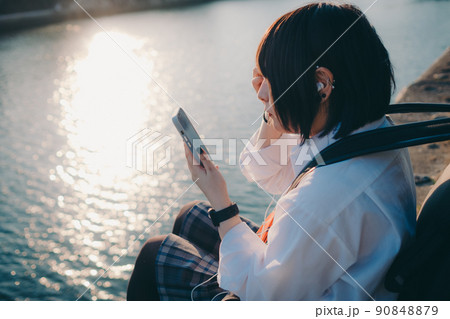 ギターとスマートフォン持った制服姿の女子高生と街 ギターとスマートフォン持った制服姿の女子高生と街 90848879