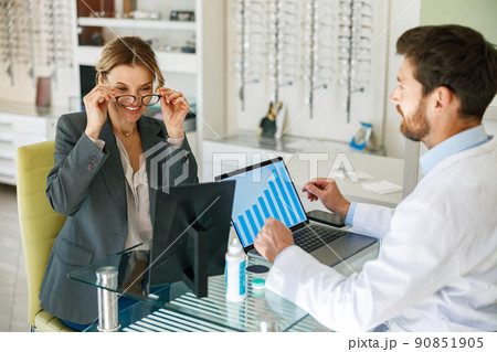 The ophthalmologist helps the client to choose a more suitable spectacle frame 90851905