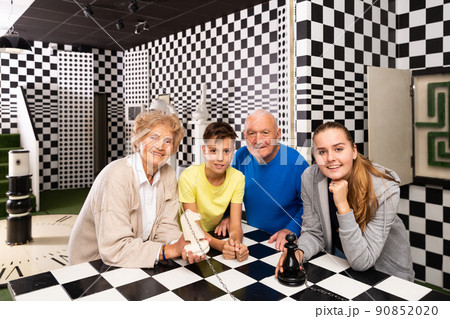 Grandparents with grandchildren are satisfied after visit of escape room stylized under chess board Grandparents with grandchildren are satisfied after visit of escape room stylized under chess board 90852020