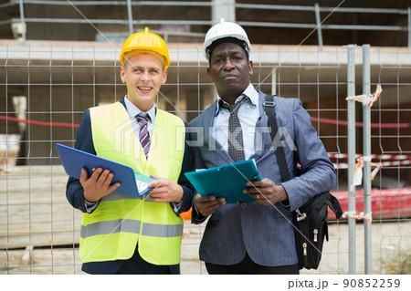 African-american architect and an engineer controlling the progress of work holding a laptop 90852259