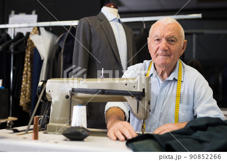 Portrait of elderly tailor working on sewing machine at studio 90852266