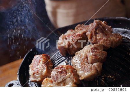 ジンギスカン、ラム肉を焼き塩コショウで味付けする 90852691