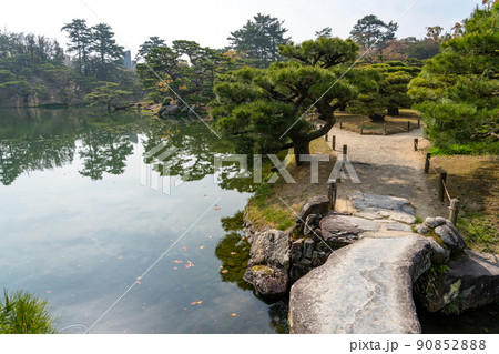 香川県高松市　栗林公園内の手入れされた松と池 90852888