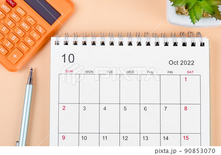 October 2022 desk calendar with calculator on beautiful background. October 2022 desk calendar with calculator on beautiful background. 90853070