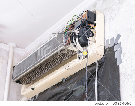 A man disassembles air conditioner for cleaning A man disassembles air conditioner for cleaning 90854060