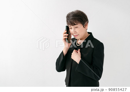 喪服の女性　スマートフォン　葬儀 90855427