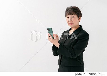 喪服の女性　スマートフォン　葬儀 90855439