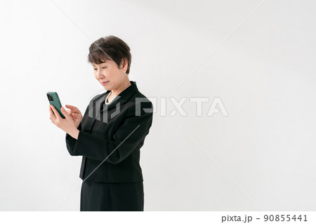 喪服の女性　スマートフォン　葬儀 90855441