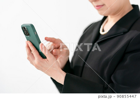 喪服の女性　スマートフォン　葬儀 90855447