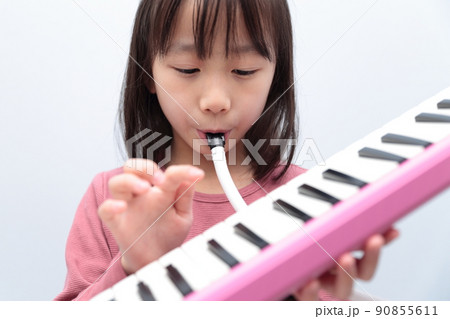 鍵盤ハーモニカを演奏する女の子 90855611