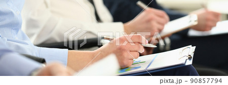 Group of business people sitting in audience with documents with charts closeup 90857794