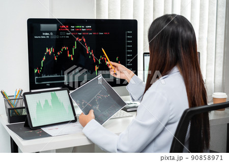 Businesswoman investor working with computer, tablet and analyzing graph stock market trading planning with chart data financial investment planning 90858971