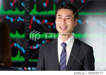 チャート画面の前で会話をするビジネスパーソン チャート画面の前で会話をするビジネスパーソン 90859177