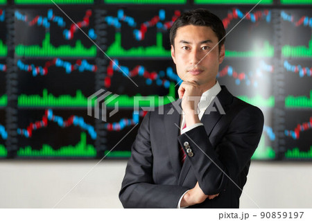 チャート画面の前に立ち視線を向けるビジネスパーソン チャート画面の前に立ち視線を向けるビジネスパーソン 90859197