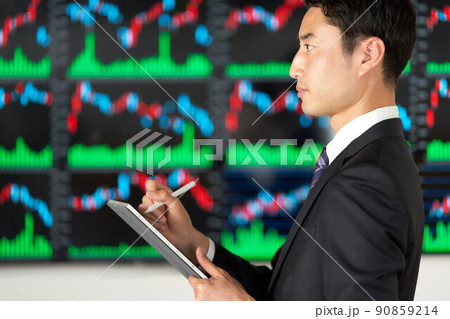 チャート画面の前に立つビジネスパーソンの横顔 90859214